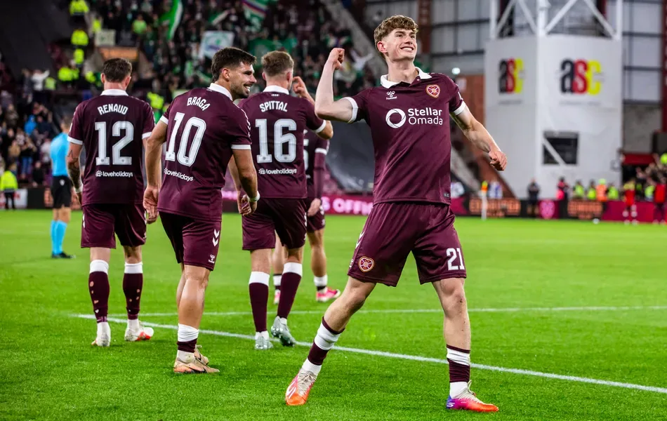 Beau Reus saved two penalties as Hearts overcame Rapid Vienna to reach the Conference League group phase